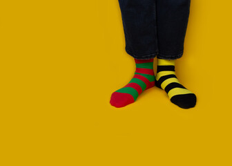 Legs with different stripes socks on background with copy space. World Down syndrome day background. Down syndrome awareness concept.