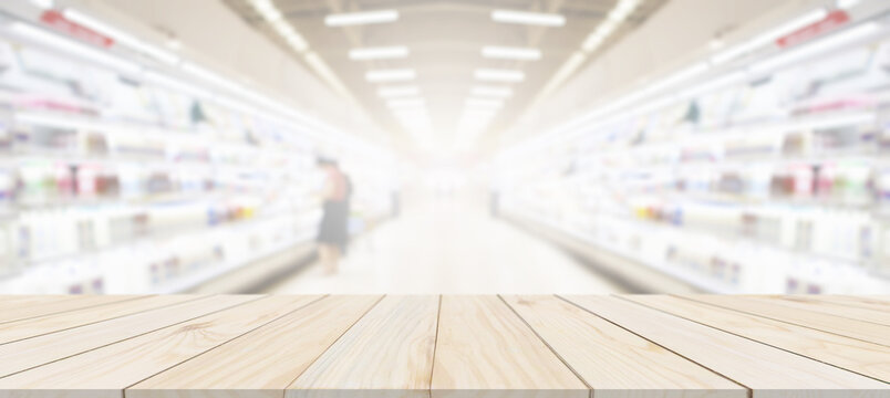 Wood table top with supermarket grocery store blurred background with bokeh light for product display