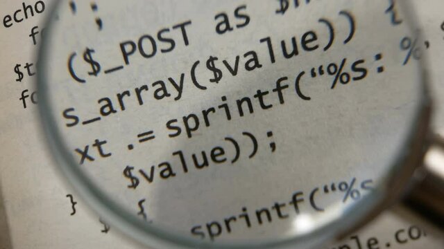 magnifying glass increases the programming code on paper book. software development concept.