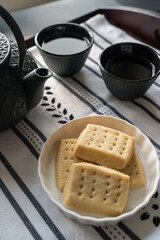 plateau avec une assiette de biscuits au beurre, deux tasses et une théière
