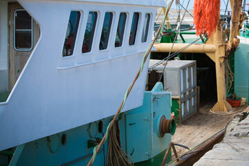 Moored fishing boat with wheelhouse windows and ropes in a harbor © Bjorn B
