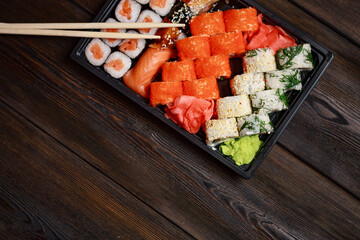 sushi rolls with seafood on a wooden table and chopsticks