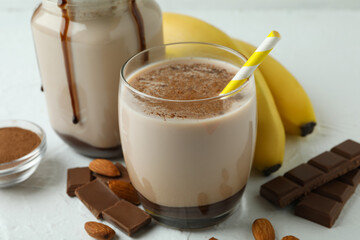 Concept of delicious food with chocolate milkshake and banana on white textured table