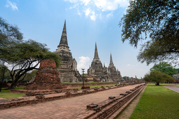 Naklejka premium three ancient pagodas (chedies) ruins of old Siam capital Ayutthaya at Wat Phra Si Sanphet temple and walk way, famous place for travelling in Phra Nakhon Si Ayutthaya Province, Thailand 