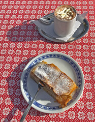 Heiße Schokolade mit Schlagsahne und Apfelstrudel in einem Cafe im Berchtesgadener land