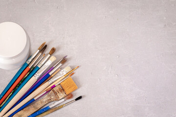 Obraz premium Professional dirty working artist brushes and paint on marble table. Flat lay, top view
