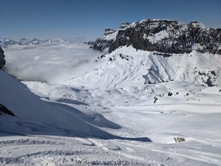  Ski tour in the Swiss mountains. View of the snowy mountains above the clouds. Fantastic views and a powder run. Glarus. Skimo