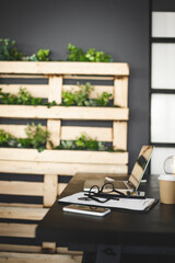 indoor interior shot of a sustainable, modern ecological workplace with lots of green plants and dark wall