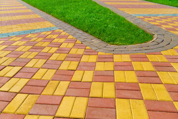 Obraz premium walkway made of paving slabs and green grass as a background, bright sunlight