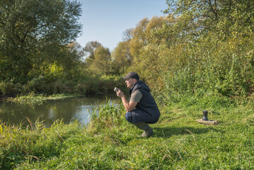 Young man with a mug sits in nature.