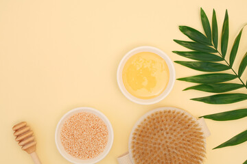 Spa body care composition on yellow background with copy space. Natural honey, dry body massage...