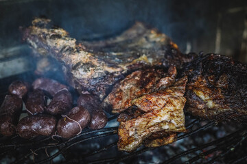 Obraz na płótnie Canvas Tipico asado argentino con carne y patatas hecho a las brasas