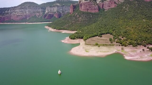 Aerial Forward: Church Tower At Sau Reservoir Near Mountains