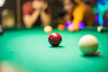 Couple playing a billiard. Focus is on billiards ball.