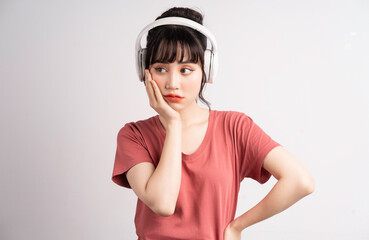 Young Asian woman using wireless headphone to listening music
