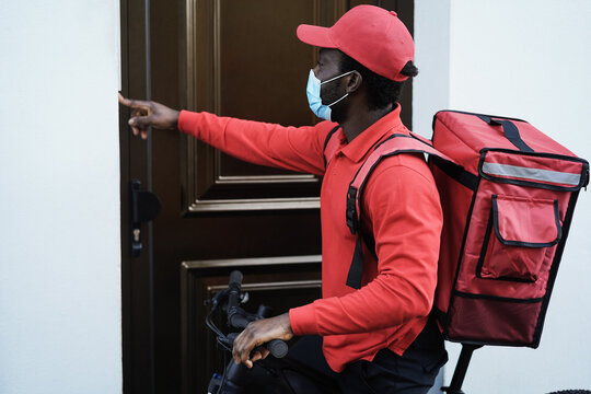 African Delivery Man With Electric Scooter Ringing The Doorbell - Focus On Face