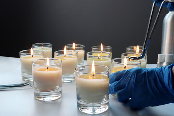 aroma scented candle glasses are on the white table with fragrance oil during the burning test...