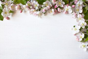 Spring white wooden background with apple tree flowers and space for text.