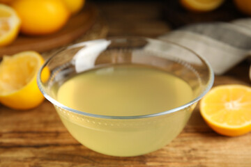 Freshly squeezed lemon juice in glass bowl on wooden table