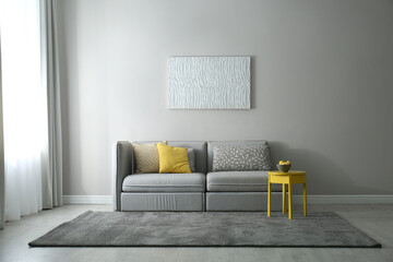 Stylish living room with sofa. Interior design in grey and yellow colors