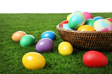Fototapeta na wymiar Wicker basket with bright painted Easter eggs on green grass