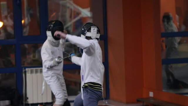 Teenagers practicing fencing at a fencing school 
