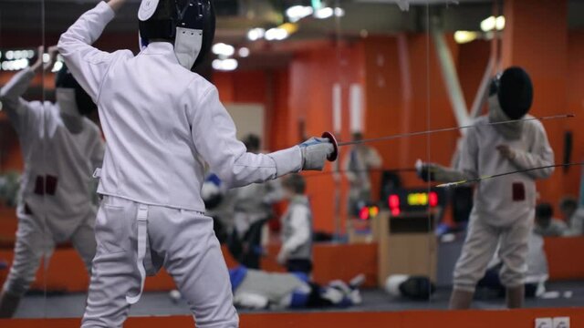 Kids practicing fencing at a fencing school 