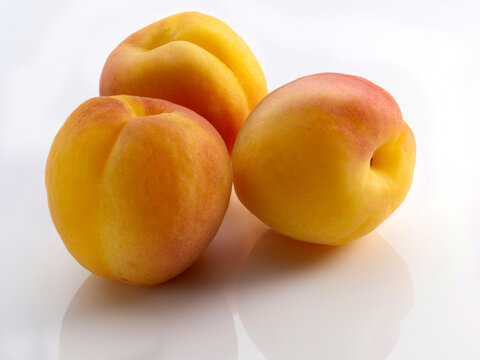 albaricoques maduros sobre fondo blanco, tres albaricoques. ripe apricots on a white background, three apricots.