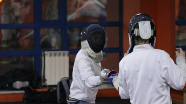 Teenagers practicing fencing at a fencing school 