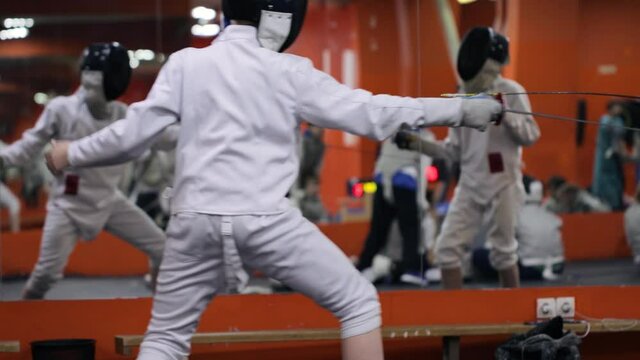 Kids practicing fencing at a fencing school 