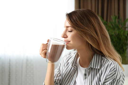 Young Woman Drinking Chocolate Milk In Room