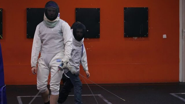 Teenagers practicing fencing at a fencing school 