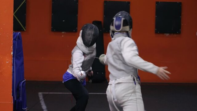 Teenagers practicing fencing at a fencing school 