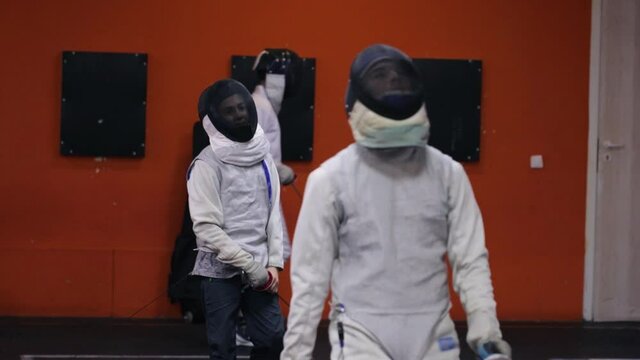 Teenagers practicing fencing at a fencing school 