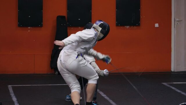 Teenagers practicing fencing at a fencing school 