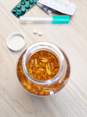 Yellow pills spilling in drug bottle, close-up. Top down view. Colorful tablets with capsules. Medical and health concepts.