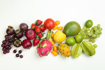 Assortment of fresh exotic fruits on white background, flat lay