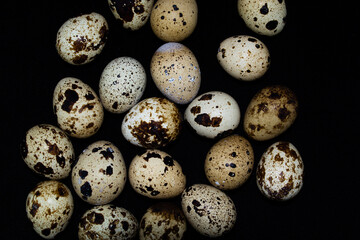 Quail eggs on a black background.