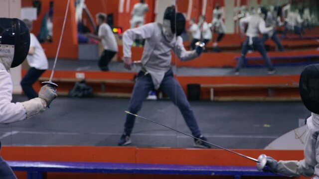 Teenagers practicing fencing at a fencing school 