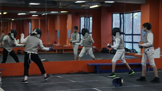 Kids practicing fencing at a fencing school 