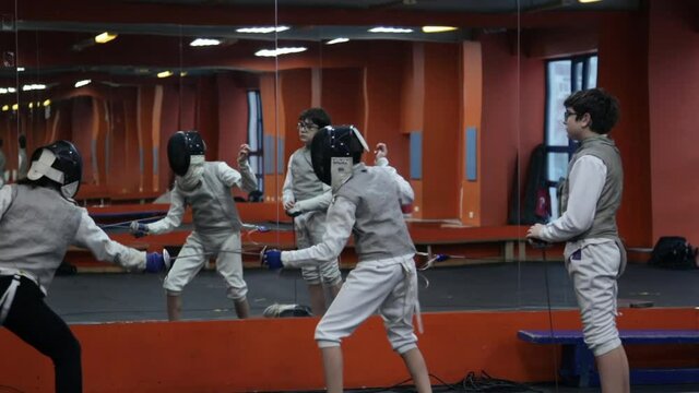 Kids practicing fencing at a fencing school 
