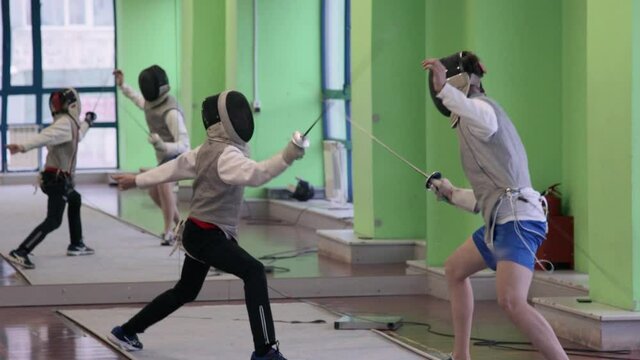 Teenagers practicing fencing at a fencing school 