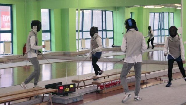 Teenagers practicing fencing at a fencing school 