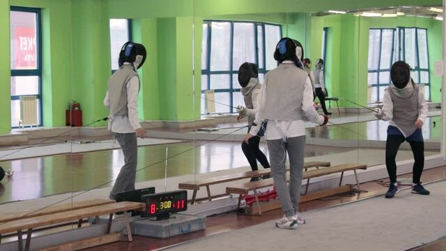 Teenagers practicing fencing at a fencing school 