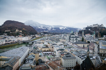 Panoramic top scenery of old town, viewpoint near museum of modern art during cloudy and gloomy winter day, river Salzach, Kapuzinerberg, Hohensalzburg Fortress, Salzburg, Austria