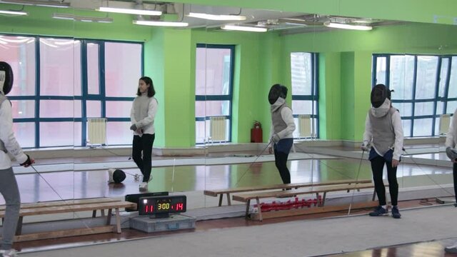 Teenagers practicing fencing at a fencing school 