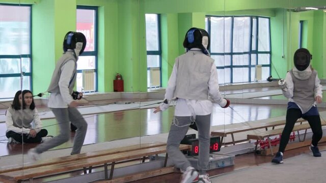 Teenagers practicing fencing at a fencing school 