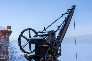 An old metal crane at the pier of the fourth northern fort of Zverev. Kronstadt fortress. Island of forts. The Gulf of Finland.