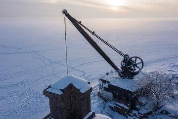 Obraz premium An old metal crane at the pier of the fourth northern fort of Zverev. Kronstadt fortress. Island of forts. The Gulf of Finland.