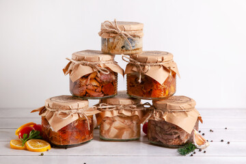 Homemade canned meat from farm poultry-goose, duck, chicken, pork and beef, canned fish from mackerel. A pyramid of glass cans with canned food